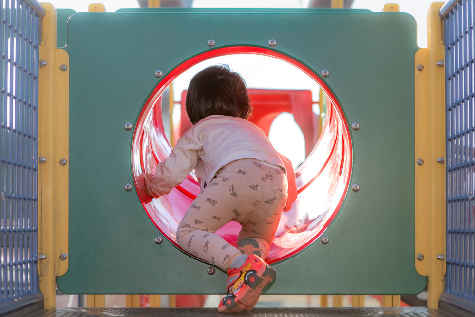 公園のトンネル遊具で遊ぶ子供の写真